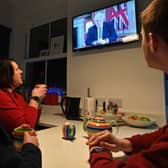 A family gather around the television to watch Britain's Prime Minister Boris Johnson give a televised message to the nation from 10 Downing Street in London (Photo by PAUL ELLIS/AFP via Getty Images)