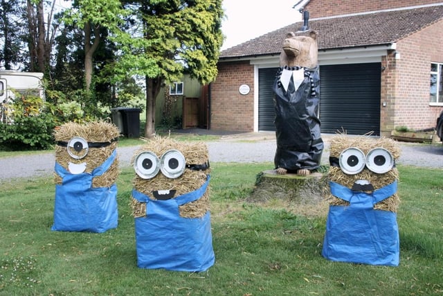 A 'Despicable Me'-inspired scarecrow display featuring the comical 'Minions'.