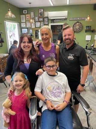 Xander Poulson after the haircut with family and Richard Burke.