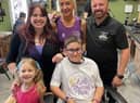 Xander Poulson after the haircut with family and Richard Burke.