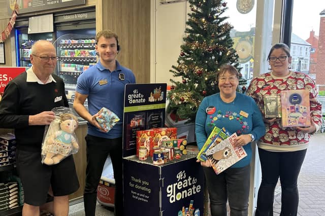 Lincolnshire Co-op Scunthorpe Food Store colleagues holding Secret Santa donations.