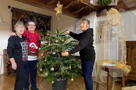 Sue Alldred, Polly Butler and Carole Harbon decorate the Bell's Christmas Tree ready for community lunch in  Wainfleet.