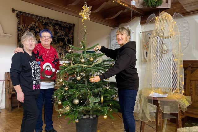 Sue Alldred, Polly Butler and Carole Harbon decorate the Bell's Christmas Tree ready for community lunch in Wainfleet.