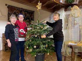 Sue Alldred, Polly Butler and Carole Harbon decorate the Bell's Christmas Tree ready for community lunch in  Wainfleet.