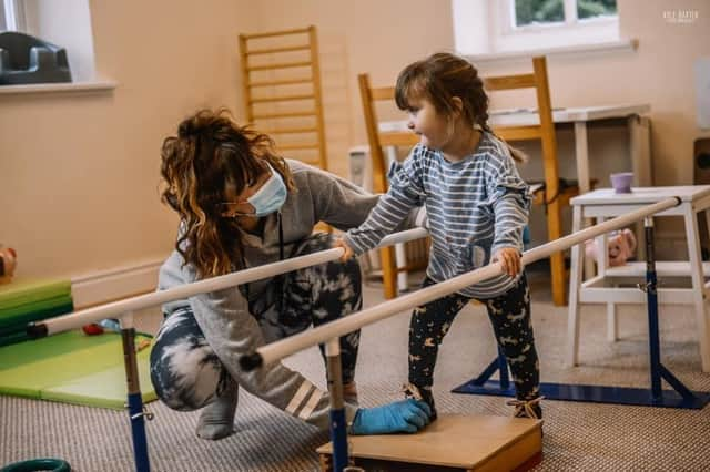 Sarah-Jayne helps a young client with physiotherapy.