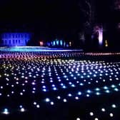 Sea Of Light - the dazzling Coldplay light show washes across the landscape in shimmering waves next to Belton House