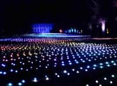 Sea Of Light - the dazzling Coldplay light show washes across the landscape in shimmering waves next to Belton House