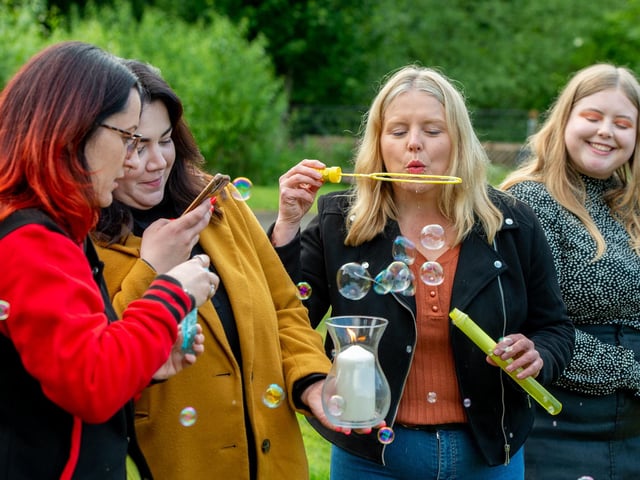 Members of BTV blow bubbles for Bethany and DJ.