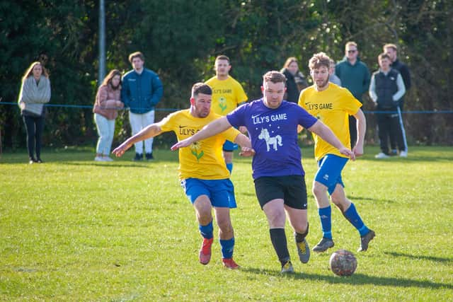 Mitch Warsop (centre) on the ball with Simon Cook (left) and Callum Hill (right) in pursuit.