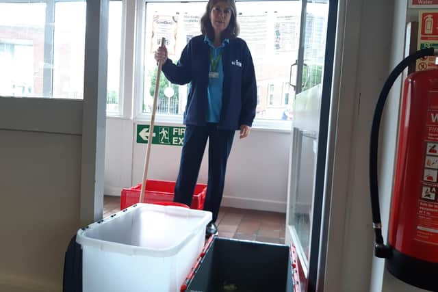 Library manager Kay Turnbull begins the mopping up process as water continues to come through the porch ceiling