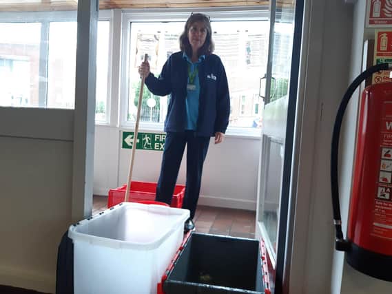 Library manager Kay Turnbull begins the mopping up process as water continues to come through the porch ceiling