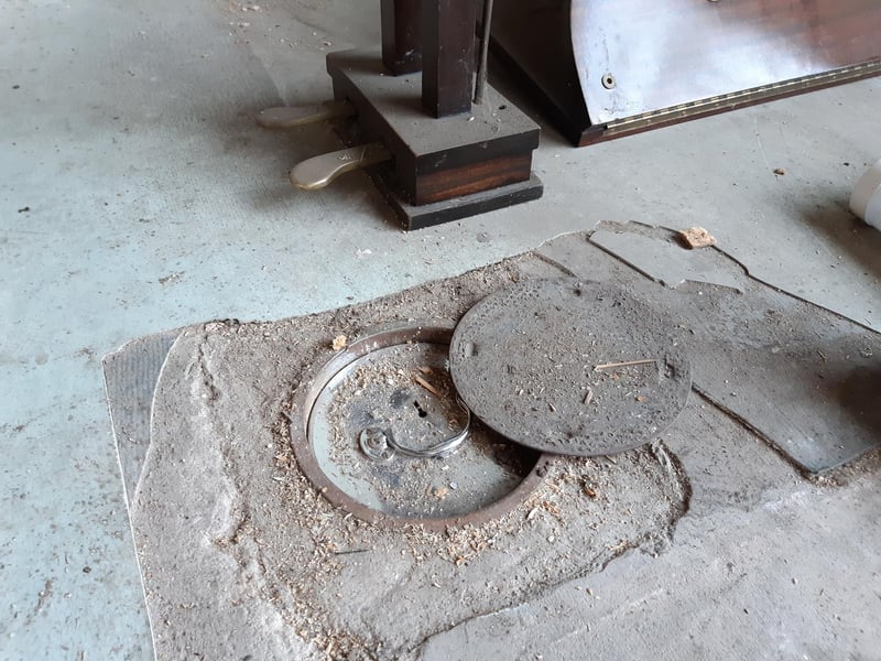 Shane initially thought this circular piece of metal on the floor would reveal access to a water isolation valve. Instead, he found it was hiding a floor safe.