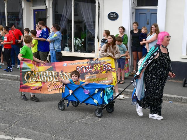 The parade passed the funfair that was in the town centre.