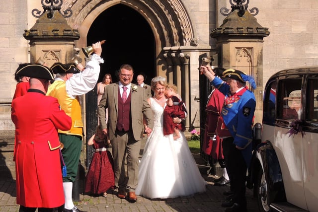 Newlyweds, James and Stacey Fleetwood get a 'bells up' from the town criers, with daughters Edith, four, and Sybil, two.