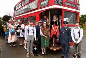 Guests in 40s and 50s dress board the bus.