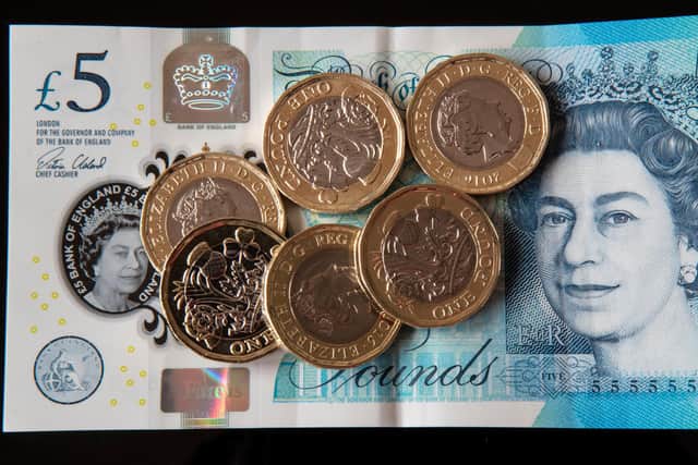 New 12-sided £1 coins on a new £5 note in Liverpool as the new pound coin entered circulation - with early teething problems expected at coin-operated machines across the country.