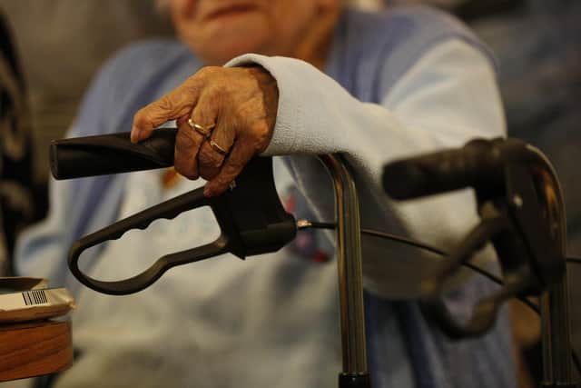 An elderly woman with her walker at a charity tea party in London.