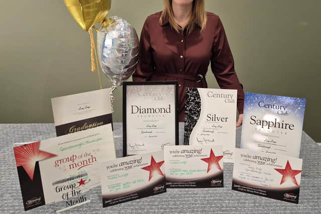 Lucy Lings with all of her group's hard-earned awards at the District Quarterly Meeting