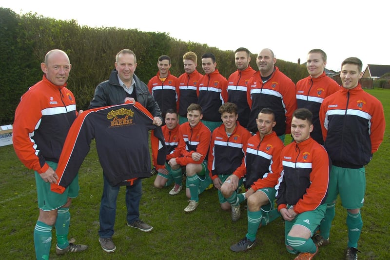 Freiston Reserves, showing off their new training tops. Captain JP Hardy is pictured in the foreground with Paul Gross, of sponsors Shephards Bakery.