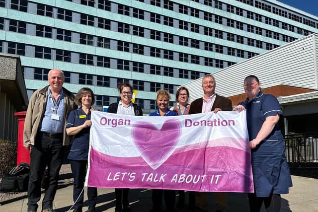 Some of the members of Lincolnshire’s Organ Donation Committee with the flag outside Pilgrim Hospital, Boston.