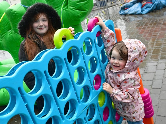 Trying out one of the free games at the Jubilee party in the Market Place are Faith Poole, 10, and Autumn Poole, three, from Boston.