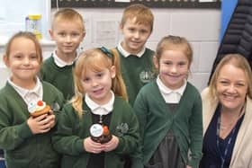 Pupils holding Voyage welcome cakes with Old Leake Primary Academy Headteacher Vicki Hardwick.