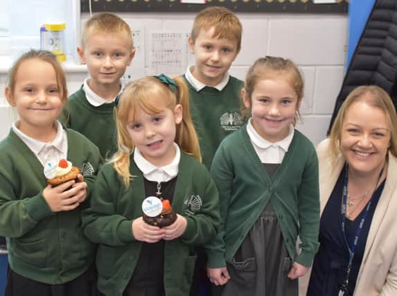 Pupils holding Voyage welcome cakes with Old Leake Primary Academy Headteacher Vicki Hardwick.