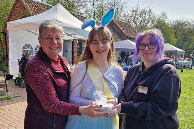 Summer (centre)  making a recent presentation to the Village Church Farm at an Alice in Wonderland event.