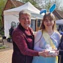 Katie (centre)  making a recent presentation to the Village Church Farm at an Alice in Wonderland event.