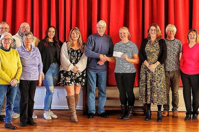 Louth community pantomime club handing over £800 to Hayley Hodson from Mimi's Mission from the proceeds of Robin Hood - The Panto.
