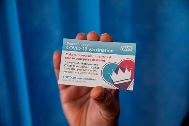 You receive a card to show you have been vaccinated (Photo by Jack Hill / POOL / AFP) (Photo by JACK HILL/POOL/AFP via Getty Images)
