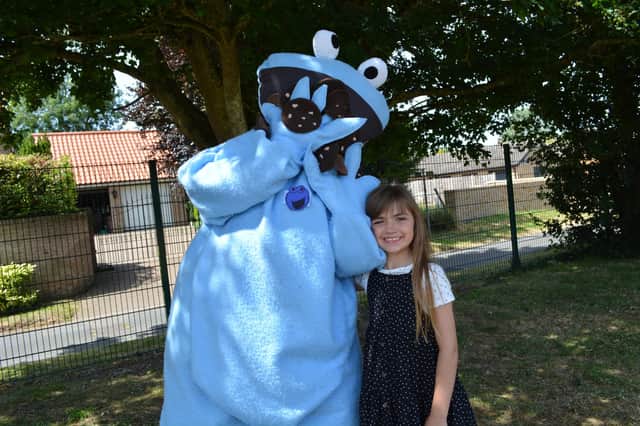 Macey Carter (8) with the Cookie Monster scarecrow