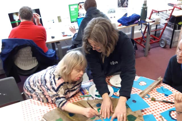 Pauline gets painting with the help of library manager Kay Turnbull