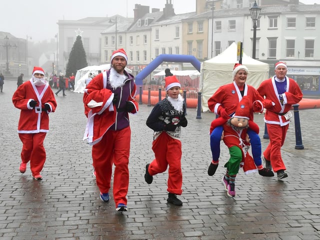Santas make their way through the Market Place.