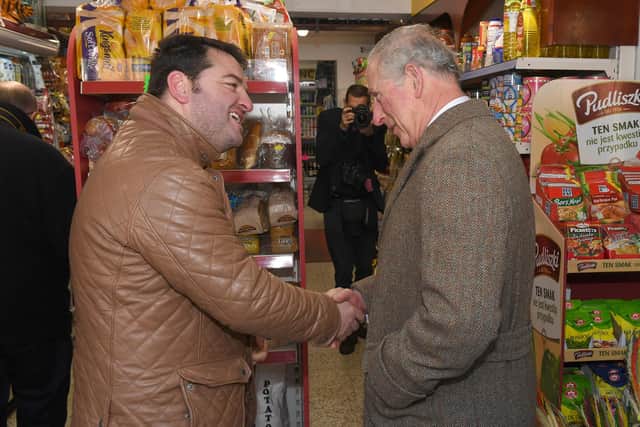 The future King shakes hands with Erhan Akyuz inside his Boston shop. Photo by David Dawson.