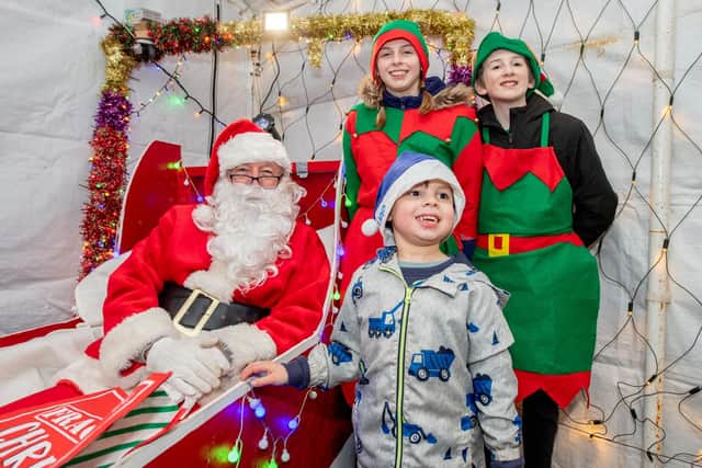Joshua Simpson, 6, meets Santa and his helpers.