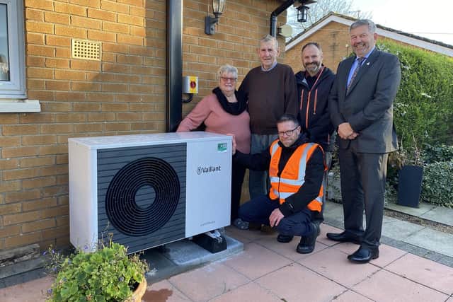 An air source heat pump fitted at a council property in Swinderby as part of the retrofitting programme. L-R: Residents Kathy and John Nicholls, Scott Masterman (NKDC), Leader of NKDC Coun Richard Wright; Front: Simon Austin (Equans).