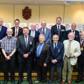 Leader of NKDC Coun Richard Wright and chairman Coun Mike Clarke with the 13 veterans who received badges for their service.