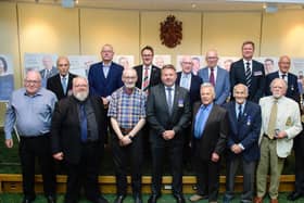 Leader of NKDC Coun Richard Wright and chairman Coun Mike Clarke with the 13 veterans who received badges for their service.