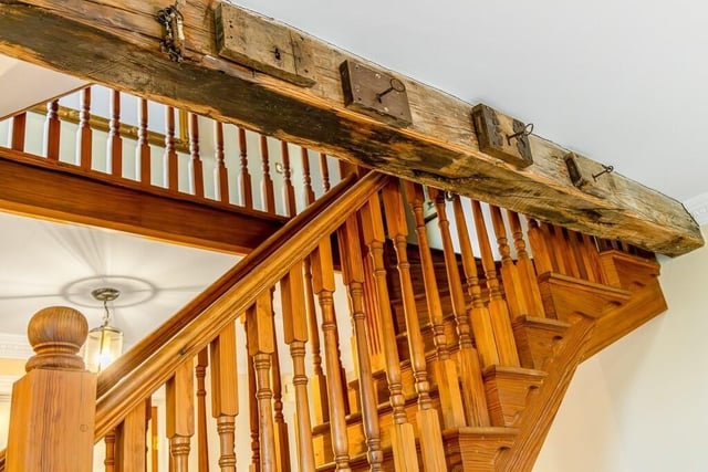 Rustic details on the wooden beams beside the stairs.