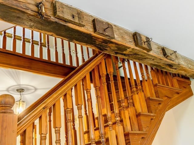 Rustic details on the wooden beams beside the stairs.
