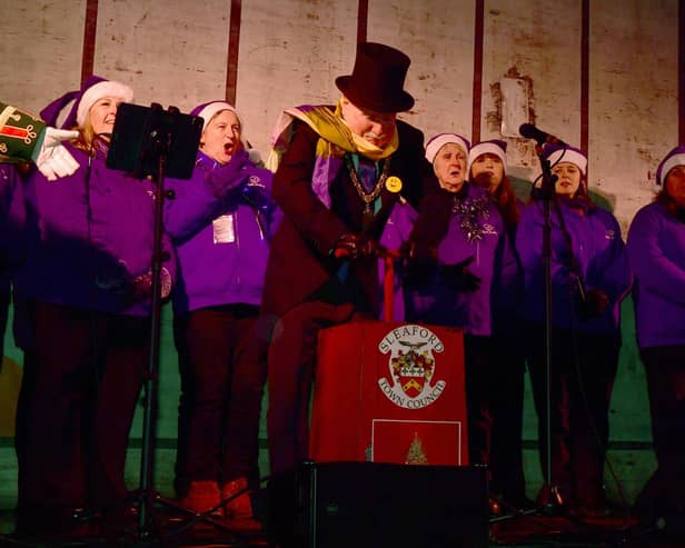 Mayor of Sleaford Coun Anthony Brand switches on the lights in the Market Place with Lincolnshire Vocal Academy.