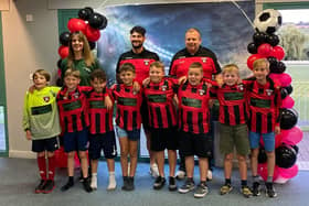 Sarah-Jayne Walker of Naomi's Garden (back left) with Louth Football Club coaches and players.