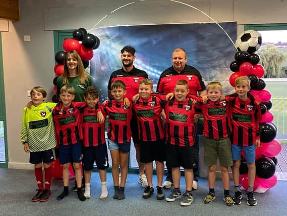 Sarah-Jayne Walker of Naomi's Garden (back left) with Louth Football Club coaches and players.