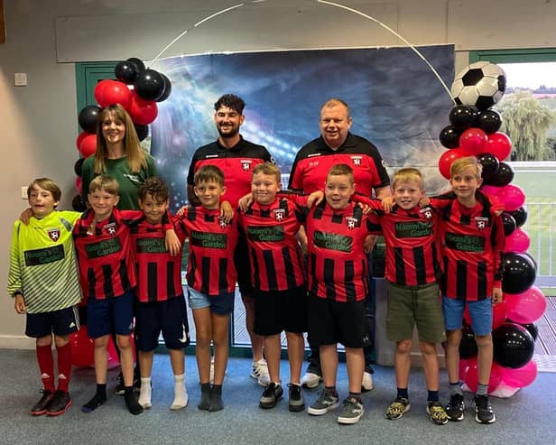 Sarah-Jayne Walker of Naomi's Garden (back left) with Louth Football Club coaches and players.
