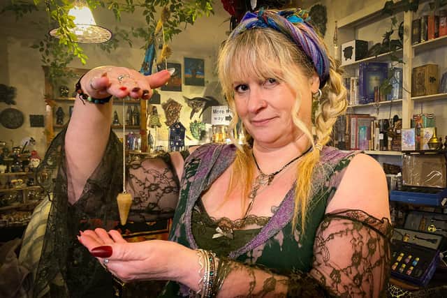 Shelley Mayes dowsing with a pendulum.