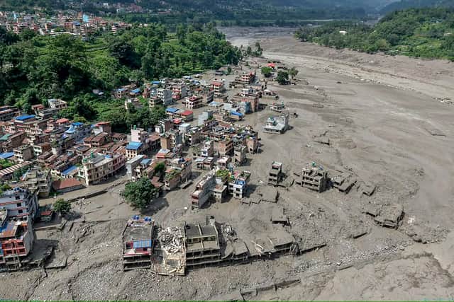 Houses lie partially submerged in muddy water along a riverside after flash floods at Trishuli Bazar in Nepal's Nuwakot district. A massive flood swept through Nepal's northern Rasuwa district on August 26, damaging roads and power infrastructure as authorities scrambled to assess the scale of the destruction. (Photo by Prabin RANABHAT / AFP via Getty Images)
