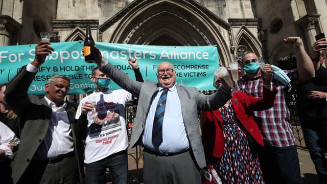 Tom Hedges outside the Appeal Court with the botle of Prosecco bought for him by his 93-year-old mother after his conviction was overturned.