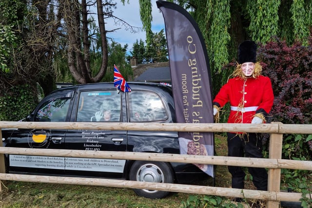 Grandma's Pudding Co's creation showing a 'Prince William' scarecrow alongside a black cab with the 'Queen' waving from inside.