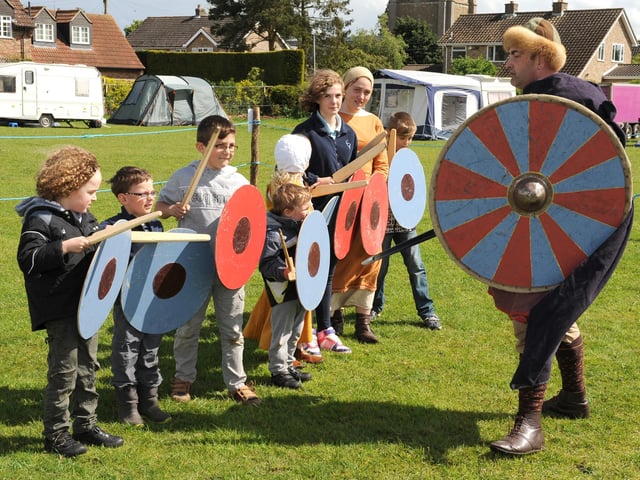 Youngsters at the Living History Day in Threekingham with Sean Raine, a member of the 'Acle' Anglo Saxon re-enactment group. As part of the event, five of the best reenactment groups in the country competed for the title ‘Best Living History Group 2014’. In the end, Acle took the title.